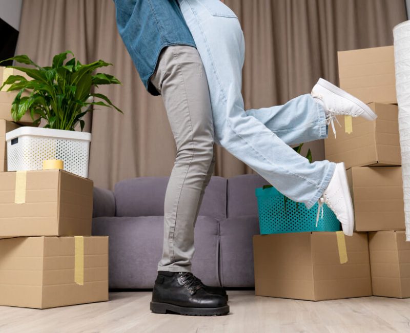 Man lifting and hugging his girlfriend with boxes around them